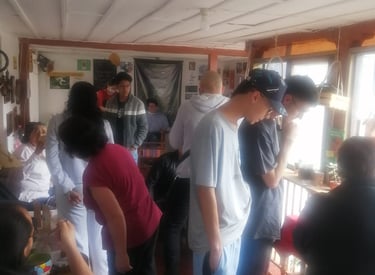 Personas participando de feria de emprendimiento, hay mesas para cada emprendedor con productos