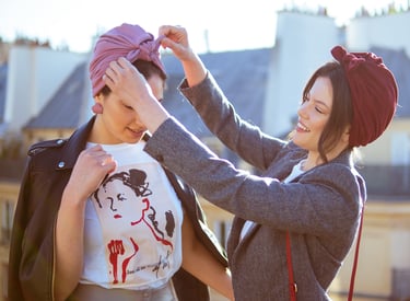 Portrait de deux femmes au turban : geste attentionné d’une amie aidant à placer le turban