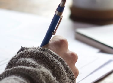 Gestion de projet - Une main qui écrit au stylo.