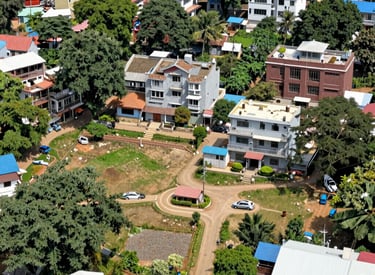 A serene view of a lush green residential plot in Dehradun with clear skies.