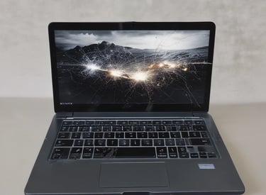 A technician carefully repairing a laptop motherboard in a bright workshop.