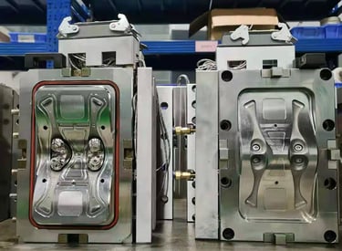 Precision plastic injection mold tool for industrial manufacturing sitting on a warehouse workbench.