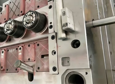 Precision industrial metal injection mold assembly with cylindrical rollers for plastic manufacturing.