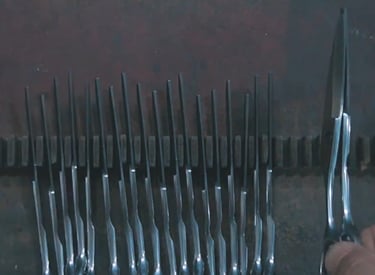 Tijeras profesionales de peluquería fabricadas y alineadas en fila; producción y control de calidad.