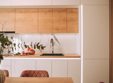 oradea Modern kitchen design featuring wood cabinets, white marble backsplash, and a black sink.