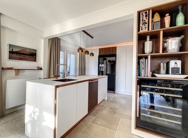 natural kitchen design with wood details, white cabinetry and stone flooring