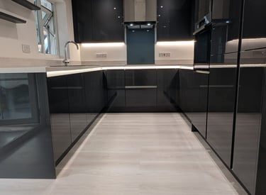 comfy kitchen with glossy black cupboards, with white countertop