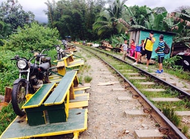 Motorcycle-powered bamboo trains parked on a railway track in the Colmbian jungle.