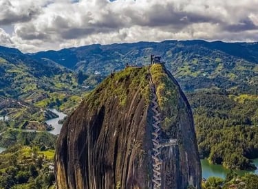 Aerial view of the massive Rock of Guatapé with zigzagging stairs and lush Colombian scenery.