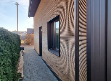 a house with a wooden siding and a brick wall