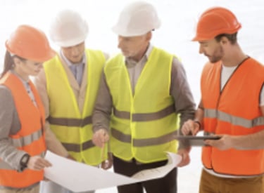 onsite team reviewing drawings with PPE on