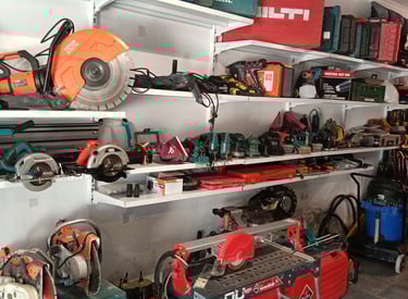 Workshop shelves organized with power tools, concrete saws, and construction equipment for rental.