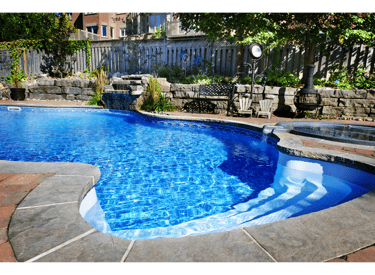 Sparkling blue kidney shaped pool set in a beautifully landscaped backyeard.