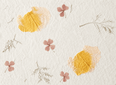 Handmade paper texture with pressed dried flowers and botanical leaves for scrapbooking.