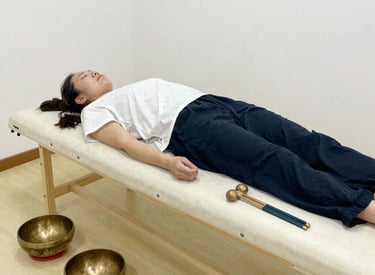 Close-up of hands gently touching a client's shoulder during energy therapy