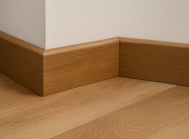 Rodapié de madera y pared blanca, primer plano.