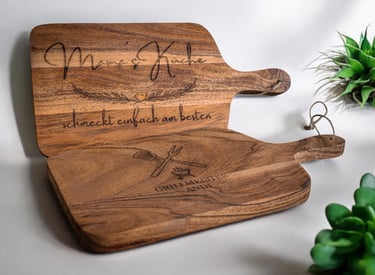 a wooden cutting board with a wooden paddle and a plant