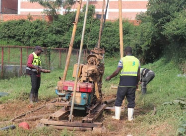 Drilling rig performing geotechnical soil investigation with engineers supervising.