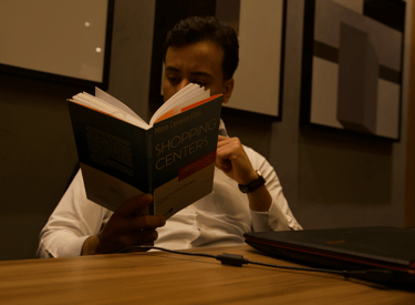 a man sitting at a table with a book in front of him