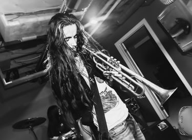 Black and white camus holding a trumpet, looking down