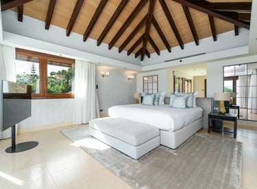 Master bedroom with vaulted ceiling and hillside views