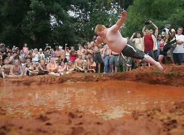 Boy jumping into mud 