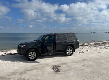 a black suv parked on a sandy beach