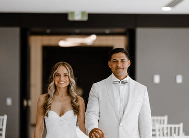 a bride and groom holding hands and smiling