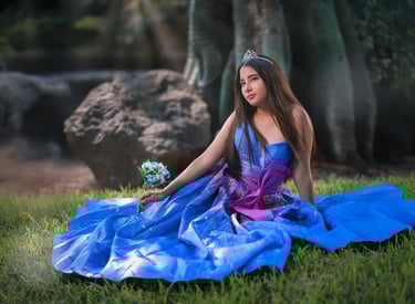 a woman in a blue dress sitting on the grass
