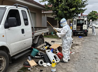 A team of cleaners working efficiently in a bright, open office space with desks and computers.