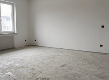 A professional cleaner carefully wiping a modern living room window, sunlight streaming in.