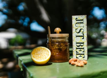 Honey jar on table with lemon and nuts