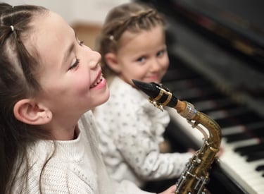 a girl playing a saxophone and saxophone with a little girl front piano