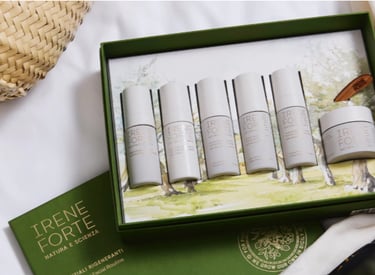 Irene Forte Skincare products displayed with Mediterranean botanicals like pistachio and olive