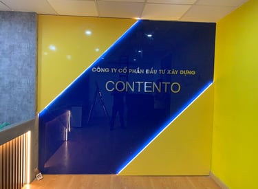 vách lễ tân bằng kính cường lực sơn mầu, trang trí đèn led tạo hiệu ứng đẹp, logo inox dán nổi