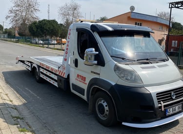 White fiat roadside assistance tow truck parked on a paved street for vehicle recovery service.