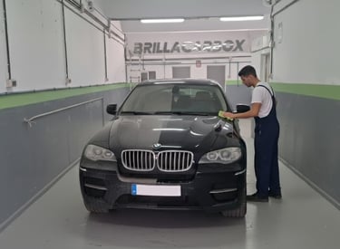 a man is cleaning a car in a garage