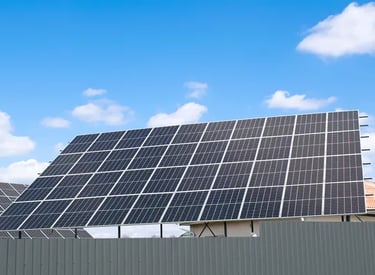 Fotografía inclinada desde abajo de paneles solares en color azul en el pasto al aire libre durante 
