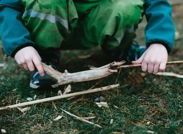 a child holding a stick in their hands