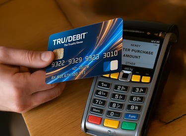 a person swiping a TRUDEBIT card through a credit card machine