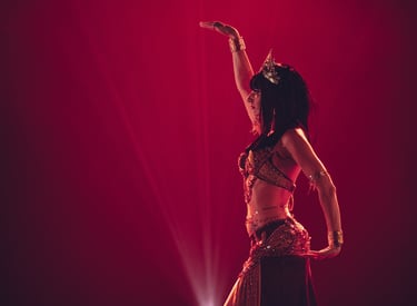 une danseuse orientale en train de danser sur un fond rouge avec des lumières