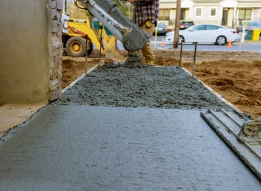 a man is laying concrete on the ground