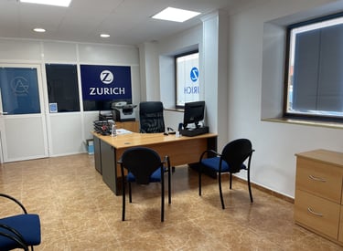Oficina de AG Seguros - Zurich con escritorio, sillas de atención al cliente y ambiente profesional 