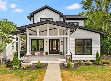a white house with a black roof and a white door