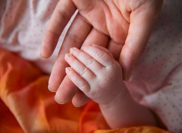 Mother holding a newborn baby's hand
