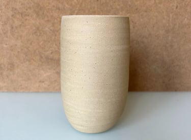 a small vase with a white vase on a table