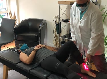 Dr. Lonna Denny utilizing cutting-edge technology like cold laser therapy to a patient.