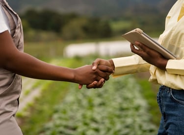 Homme et femme serrant la main dans un champ, partenariat agricole durable en Afrique