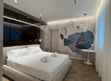 a bedroom with a bed and a large painting on the wall