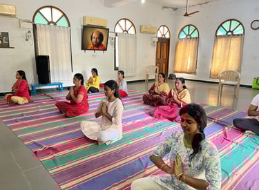 a group of people meditating on a rug in a room